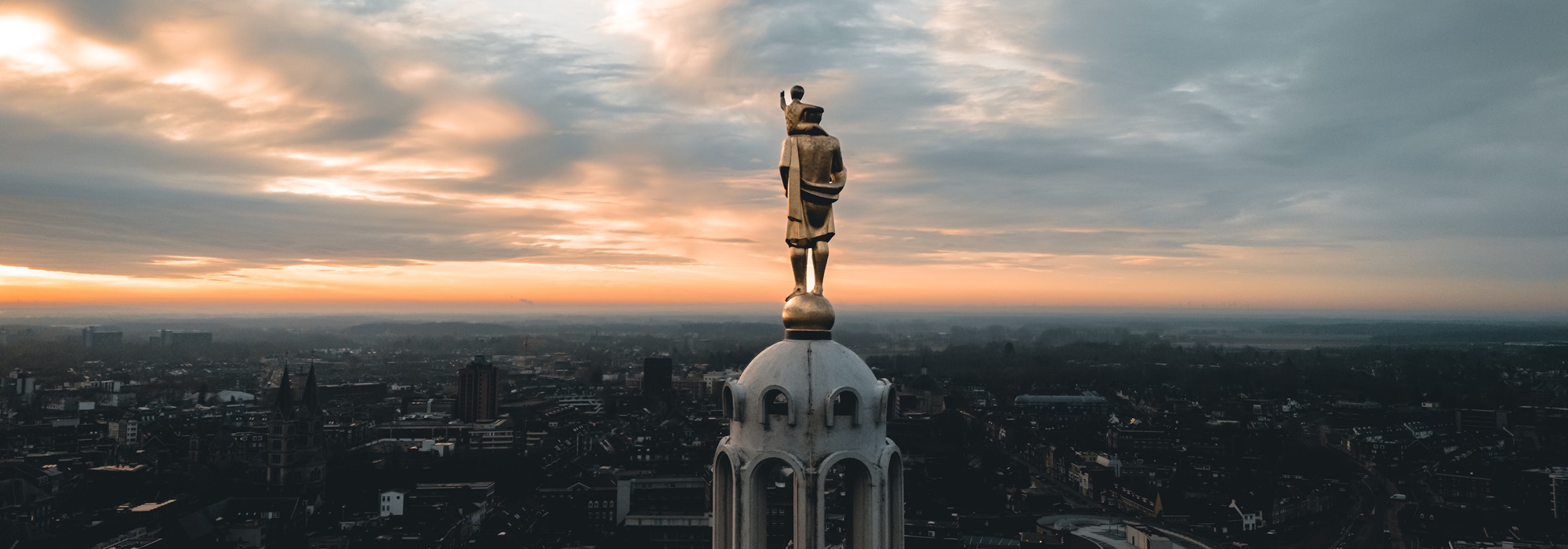 Christoffelbeeld op de kathedraal in Roermond, uitkijkend over de stad bij zonsondergang.