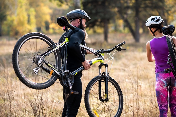 Mountain biker has grabbed his mountain bike and walks through the countryside