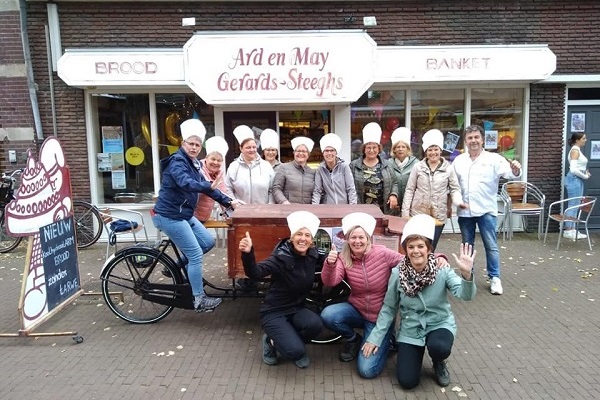 Een groep met mensen staat voor de bakkerij van Gerards.