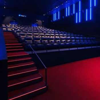 Bioscoopzaal van Foroxity Filmarena in Roermond met luxe stoelen, rode trapverlichting en moderne blauwe lichtaccenten.