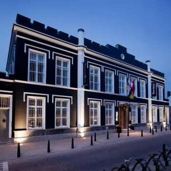 Voormalige gevangenis Het Arresthuis in Roermond, met verlichte gevel en tralies voor de ramen in de avond.
