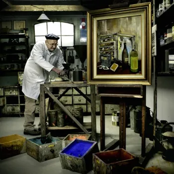 Man aan het werk in een historisch atelier in openluchtmuseum Eynderhoof, omringd door verfmaterialen en schilderij.