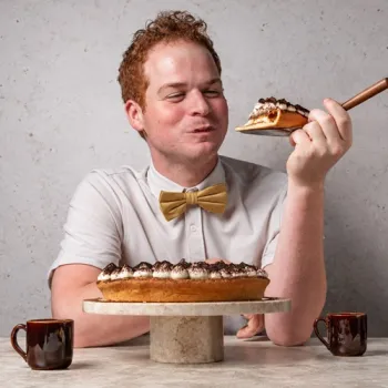 Cas Wolters proeft een stuk tiramisuvlaai met de vlaai voor zich op tafel.